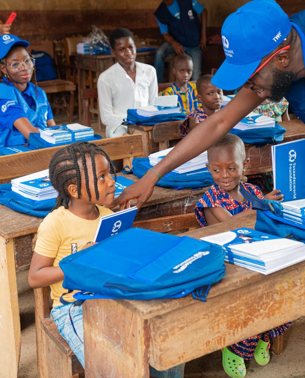 A field officer handing a child a new school bag
